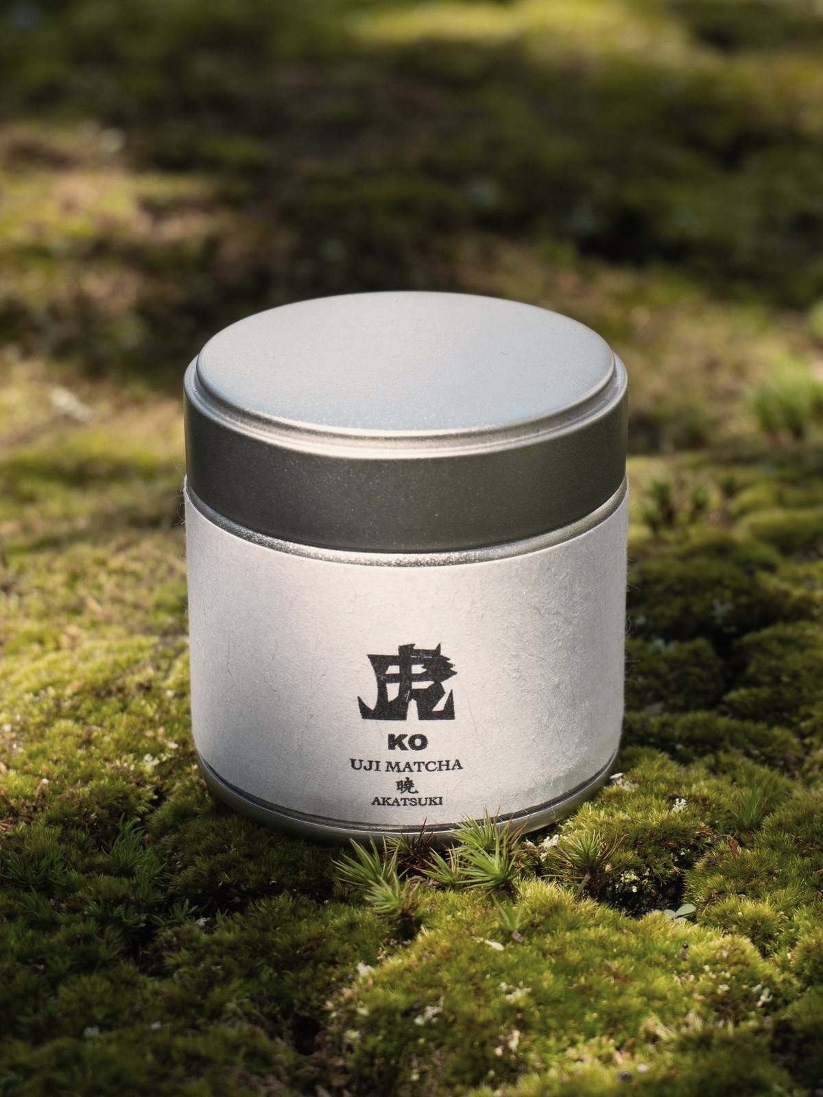 苔の上に置かれた宇治抹茶「暁」の缶
